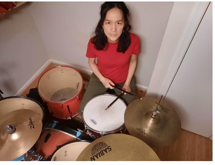 Jufang at her drum kit with Zildjian and Sabian cymbals